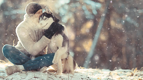 Mann mit Hund im Winter im Wald