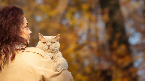 Frau mit Katze im Herbst